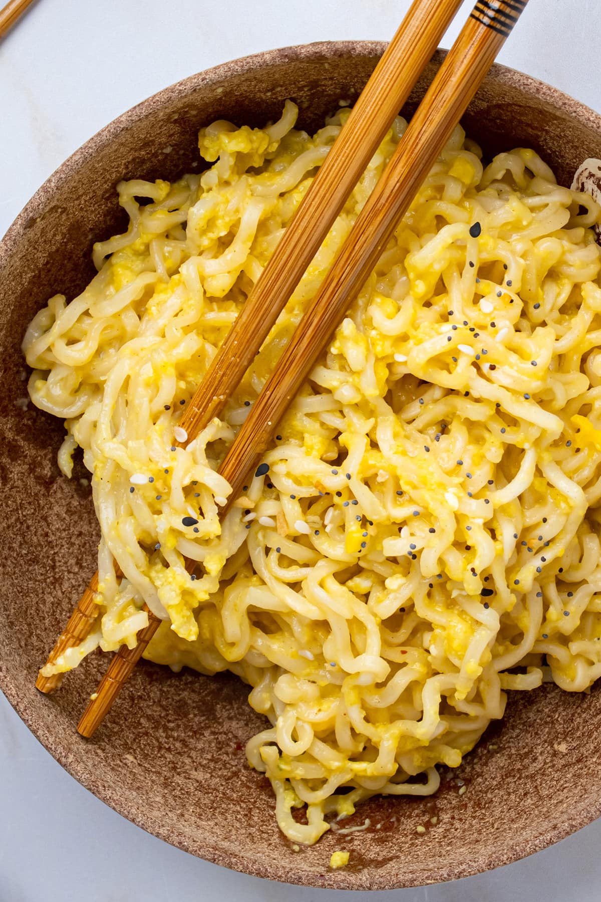 Close-up view of Kylie Jenner's ramen noodles, prepared and served in a brown bowl with a set of wooden chopsticks.