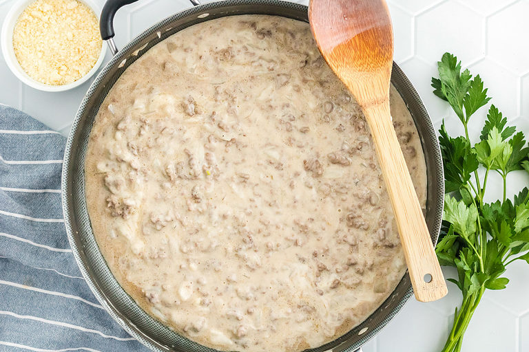 Ground beef, onions, garlic, and alfredo sauce in a large skillet.