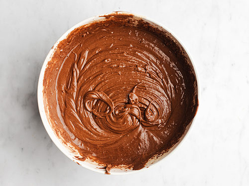 Overhead view of chocolate mochi brownie batter in a large white bowl.