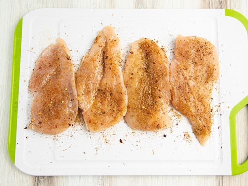 Seasoned jerk chicken on a cutting board.