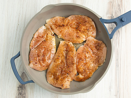 Cooked chicken cutlets in a large skillet.