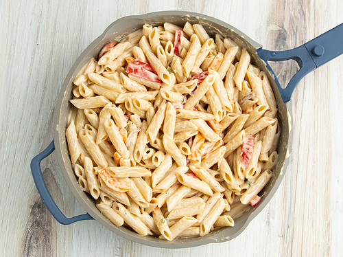 Alfredo pasta and veggies in a large skillet.
