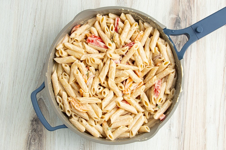 Alfredo pasta and veggies in a large skillet.