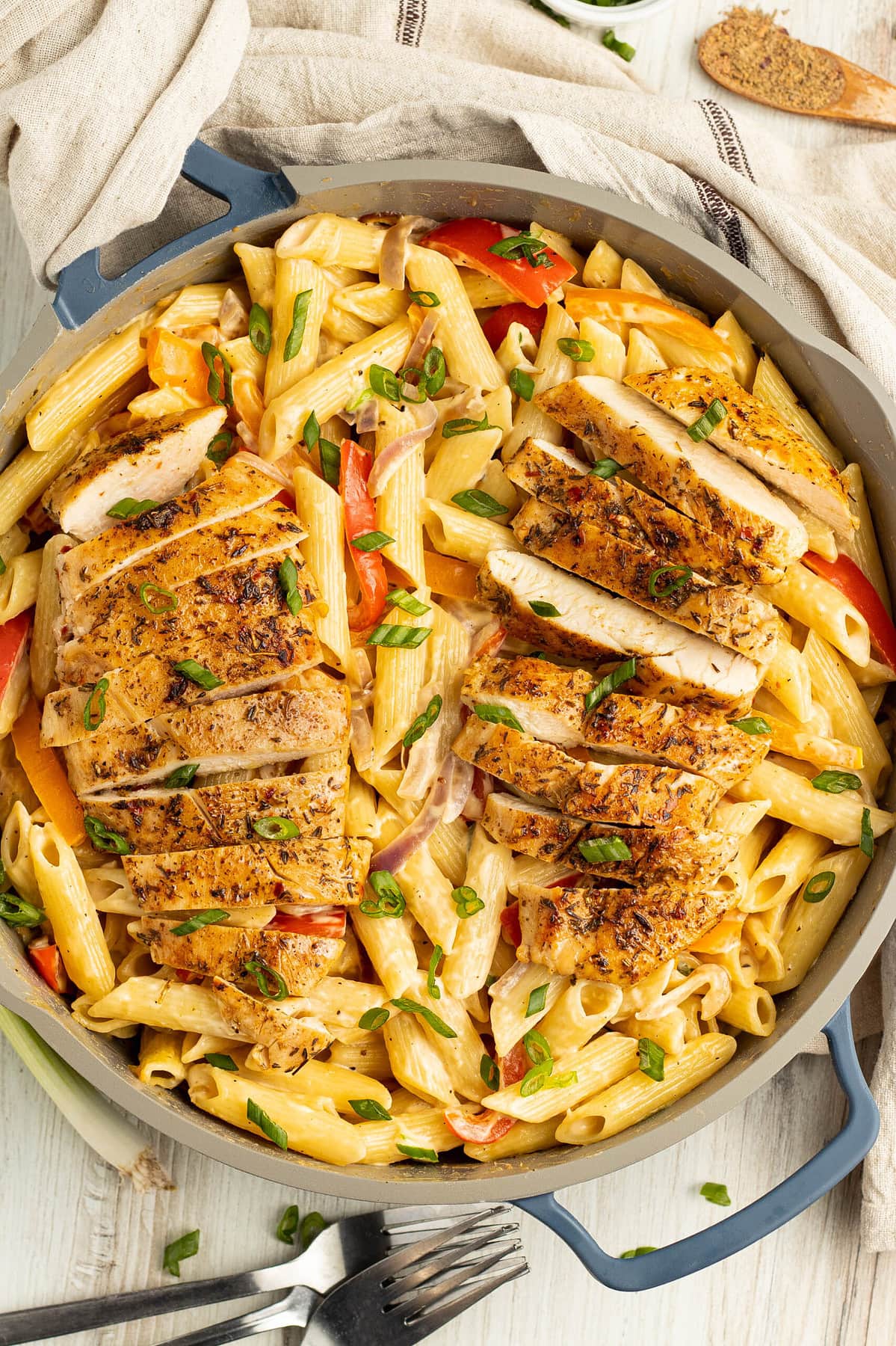 Overhead view of jerk chicken alfredo in a large skillet.