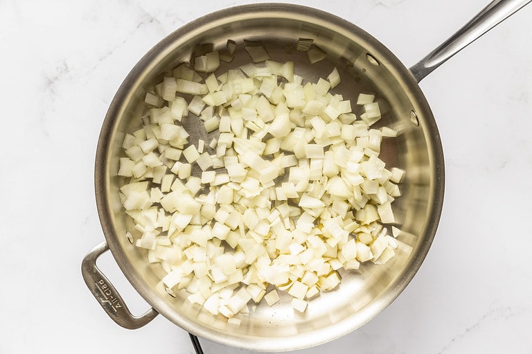 Diced onion in large silver saucepan with olive oil.