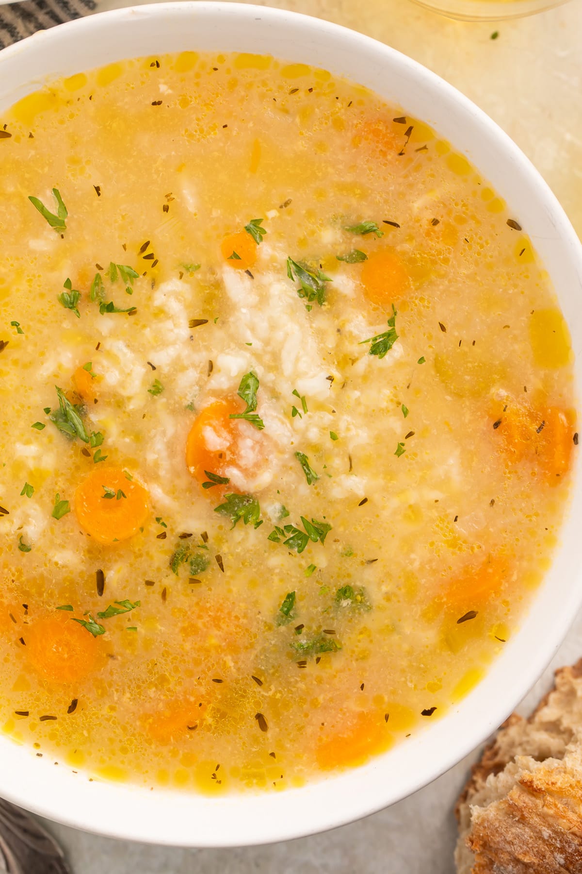 Overhead close-up photo of a large white bowl of chicken and rice soup cooked in the Instant Pot.
