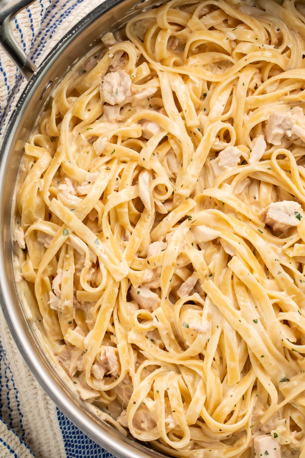 Close-up of a large pan holding creamy tuna alfredo with fettuccine.