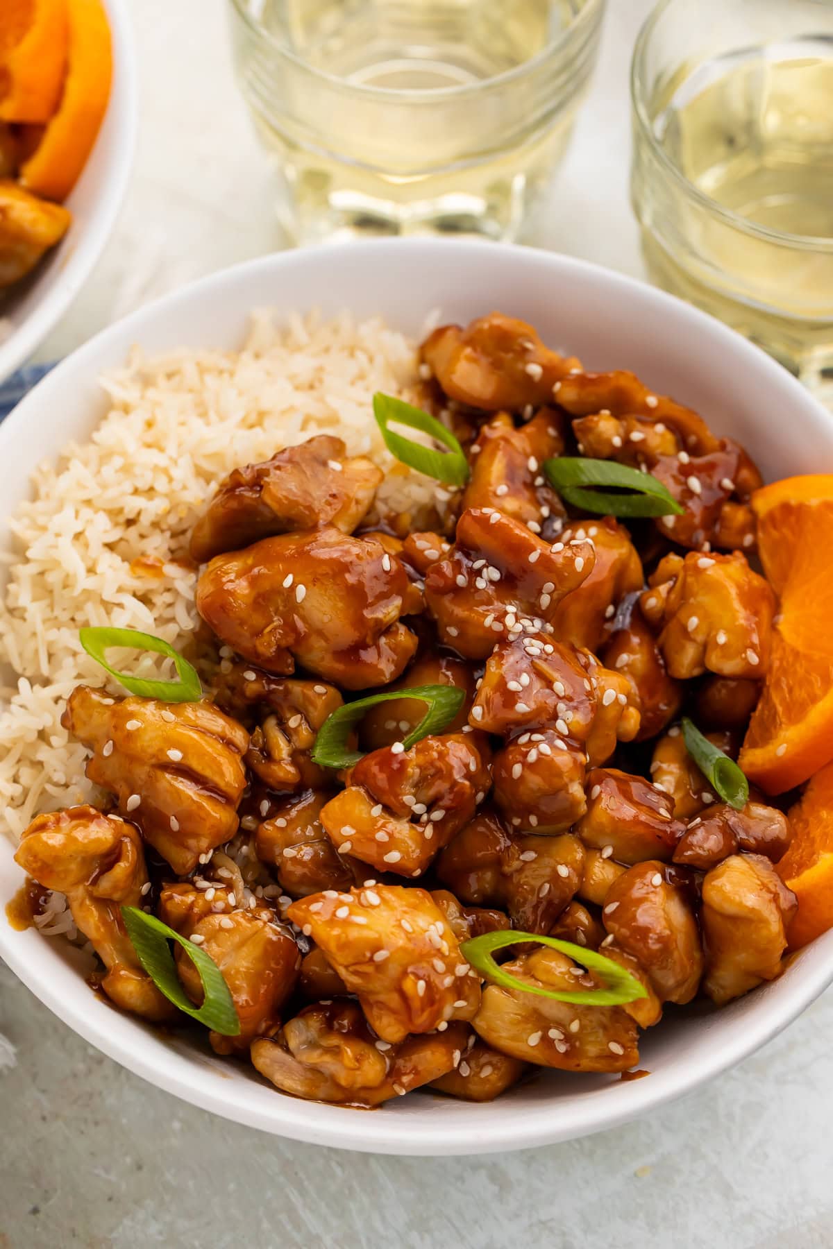 Tangerine chicken in a bowl with white rice.