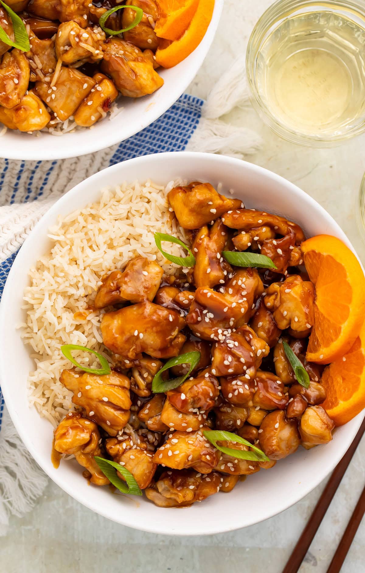 Tangerine chicken in a bowl with white rice.