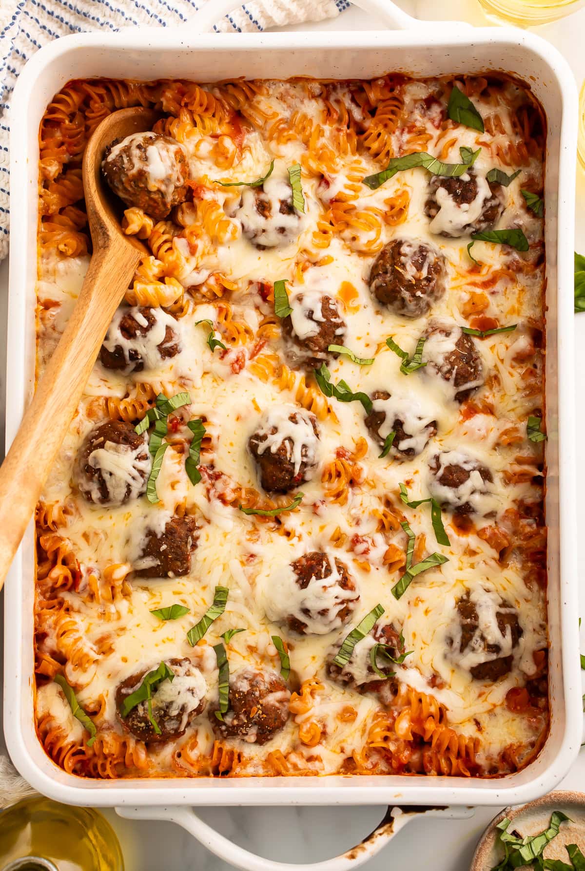 Overhead shot of a meatball casserole topped with melted cheese.