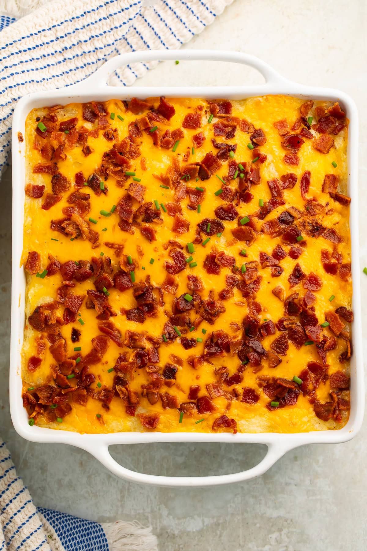 To down view of a Loaded Meatloaf Casserole in a white baking dish with a blue and white kitchen linen on the countertop.