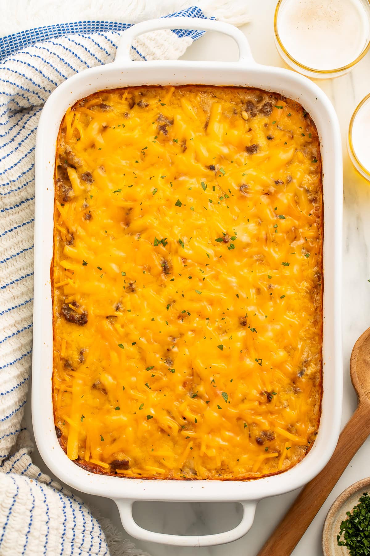 Overhead picture of a casserole in white baking dish topped with a thick layer of melted cheese.