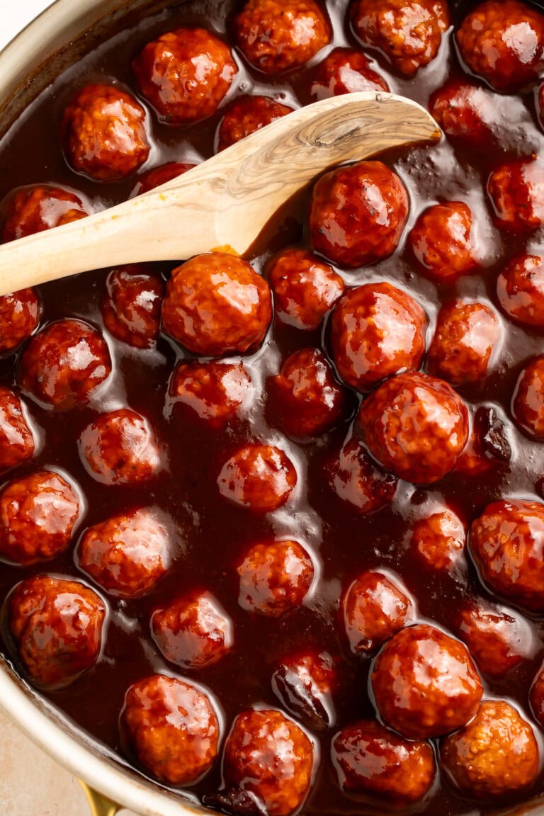 Close up of a pan of sticky glazed cranberry barbecue meatballs.