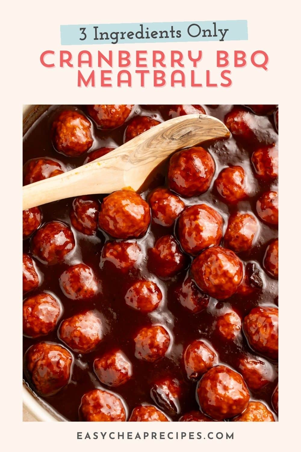 Close up of cranberry barbecue sauce meatballs being stirred with a wooden spoon. There is Pinterest text overlaid.
