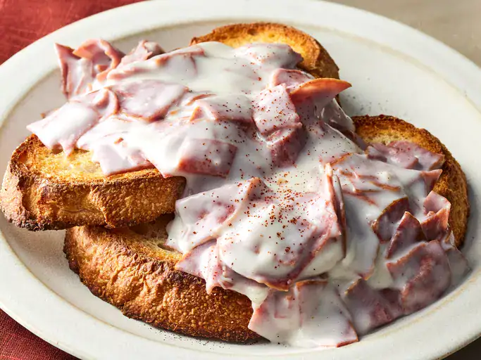 Close up of chipped creamed beef on a two slices of toast, on a white plate.