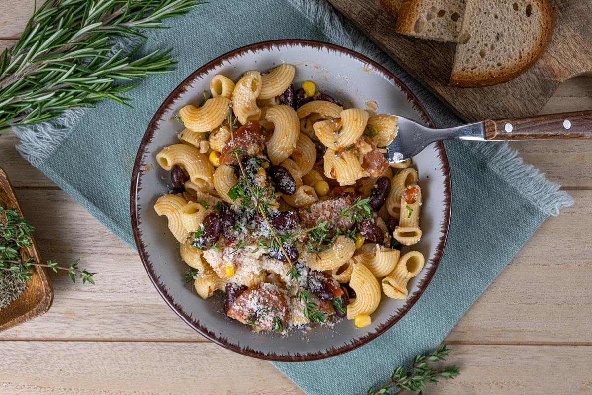 Overhead image of a bowl of hoover stew, with sliced bread and fresh rosemary pictured off to the side.