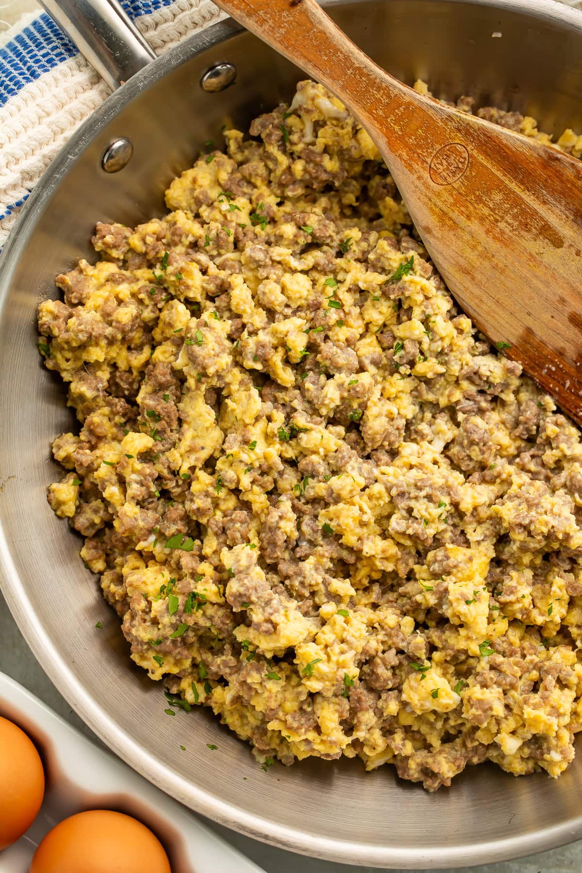 Skillet of ground beef and eggs topped with chopped parsley.
