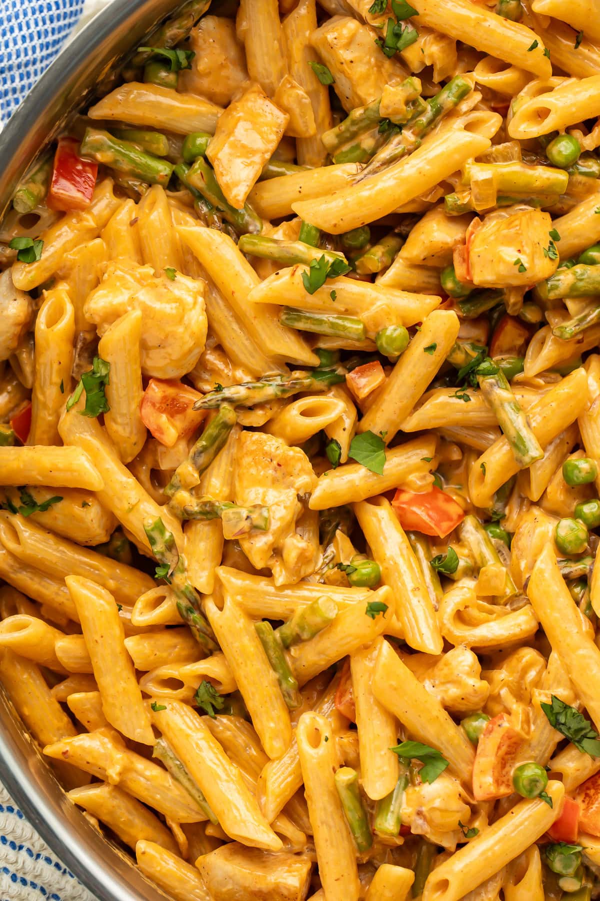 Close up of penne with chicken pieces and vegetables in a creamy chipotle sauce.