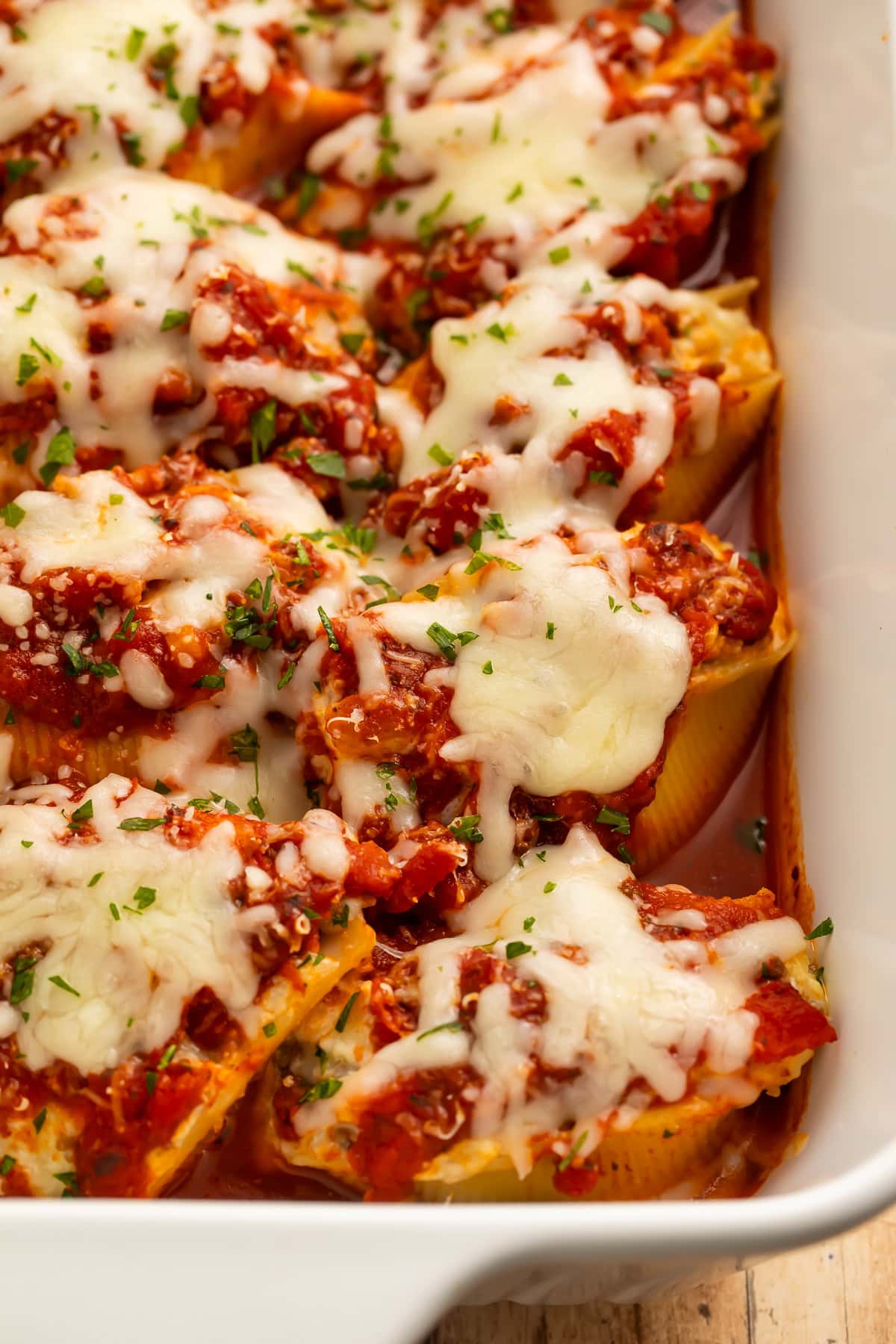 Ground beef stuffed shells in a baking dish topped with melted cheese.