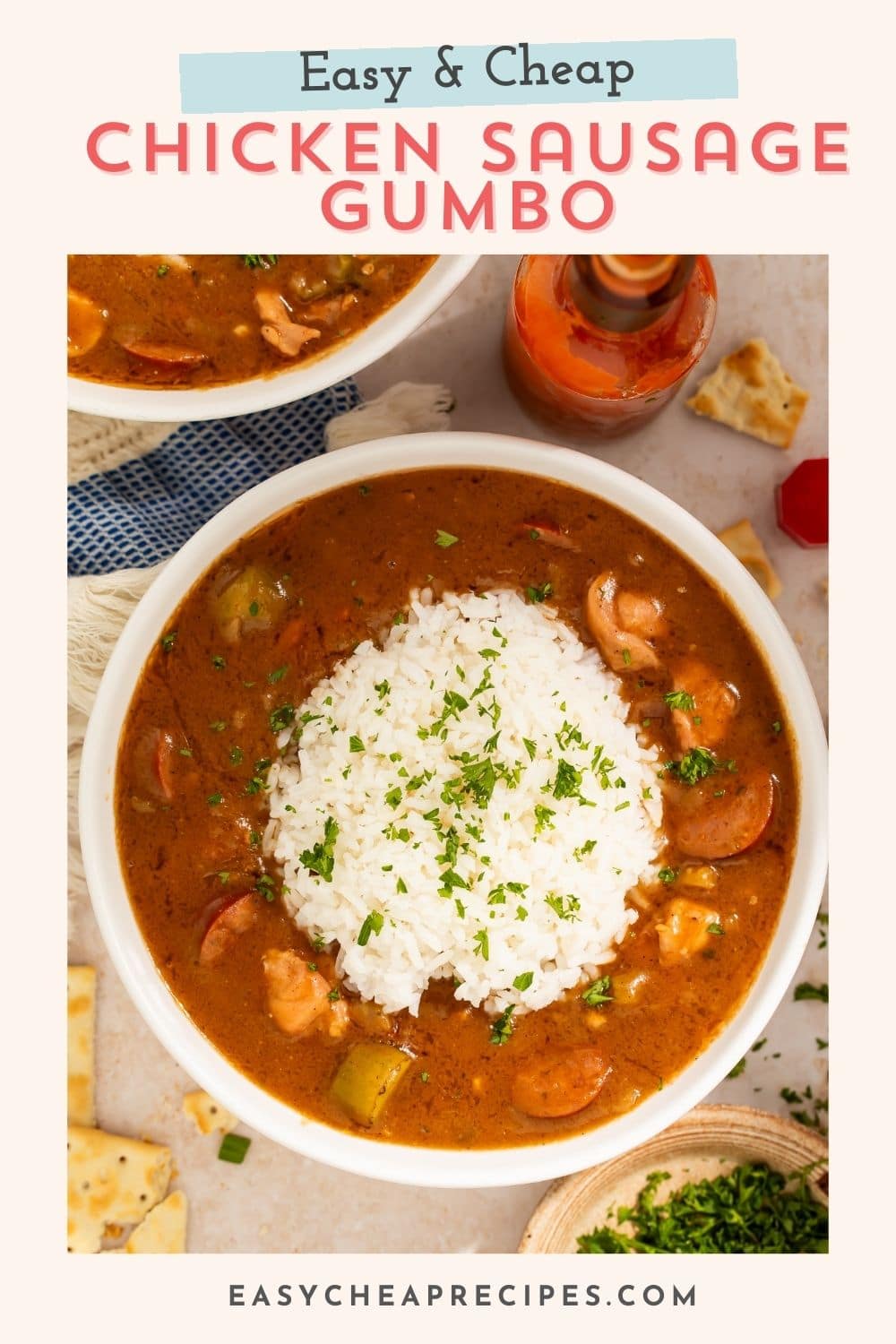 Bowl of sausage and chicken gumbo with a scoop of white rice in the middle. There is a Pinterest-optimised text overlay.